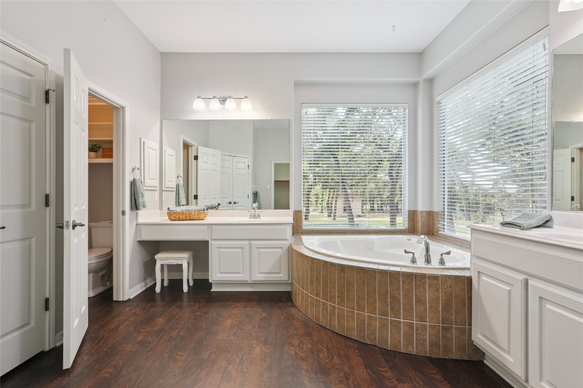 120 Juniper Trail Elgin, TX 78621 - Photo 15 of 32 Bathroom with a bath, dark wood-style floors, and two vanities