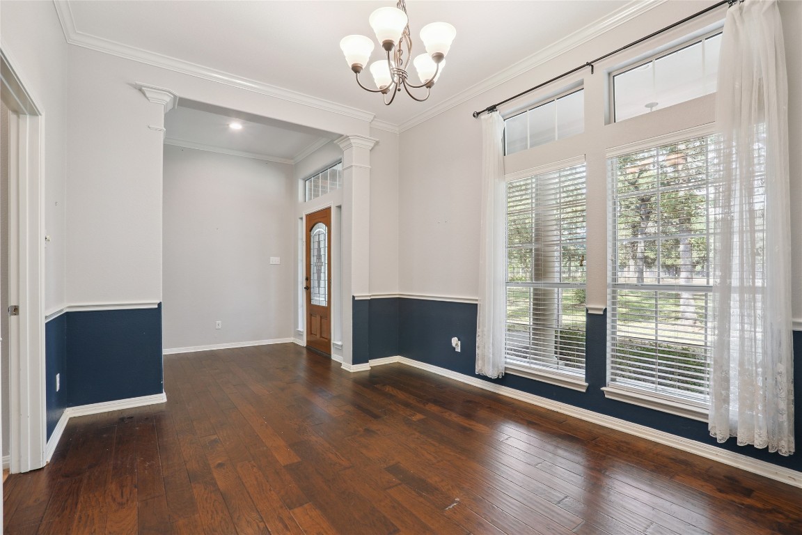 120 Juniper Trail Elgin, TX 78621 - Photo 4 of 32 Unfurnished room with dark wood finished floors, plenty of natural light, ornamental molding, and a chandelier