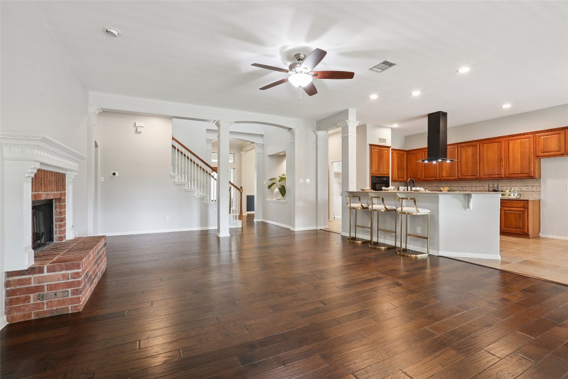 120 Juniper Trail Elgin, TX 78621 - Photo 7 of 32 Unfurnished living room with ornate columns, recessed lighting, stairs, dark wood-type flooring, and a ceiling fan