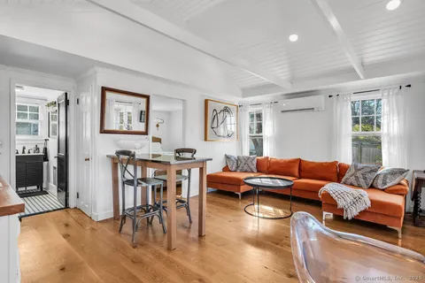 a living room with furniture wooden floor and dining table