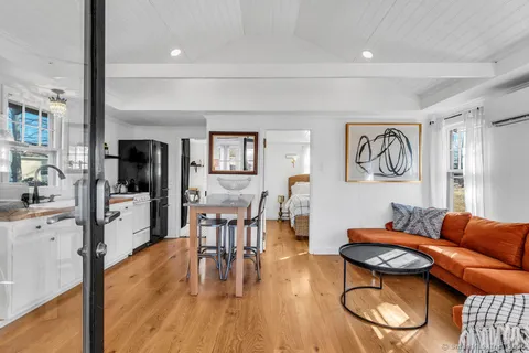 a living room with furniture a wooden floor and next to a window