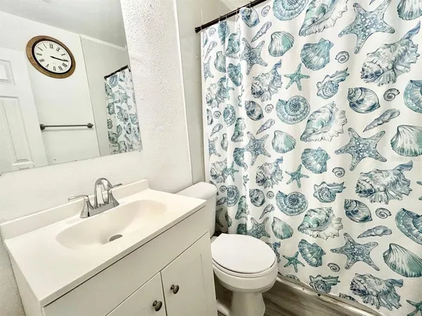 a bathroom with a sink and mirror with toilet