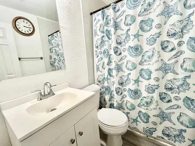 a bathroom with a sink and mirror with toilet