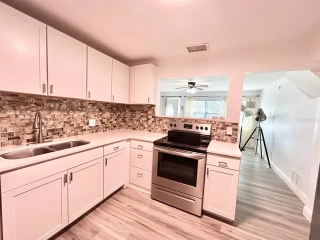 a kitchen with granite countertop white cabinets and white appliances