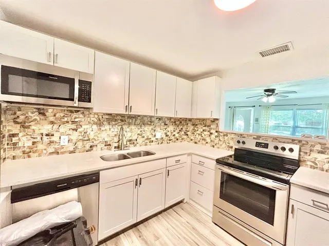 a kitchen with a sink stove and microwave