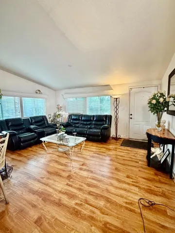 a living room with furniture and a wooden floor