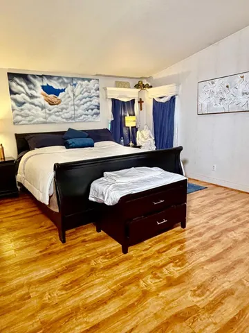 a bedroom with a bed and wooden floor