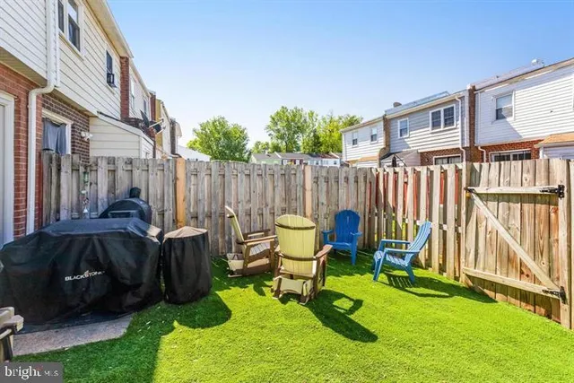 a view of a chair and table in backyard of the house