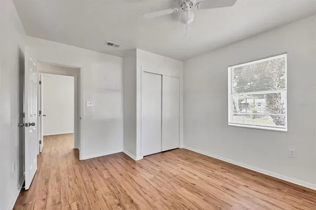 a view of an empty room with wooden floor