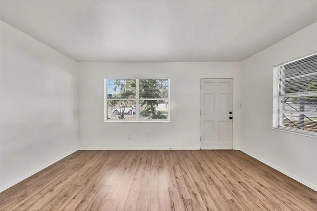 wooden floor in an empty room with a window