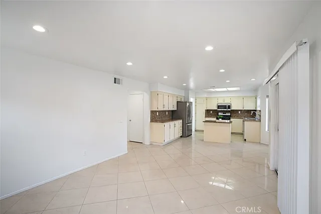 a view of kitchen with kitchen island and stainless steel appliances