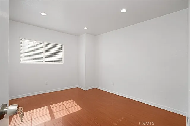 a view of a big room with wooden floor and windows