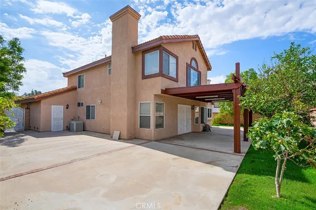 a front view of a house with a yard and trees