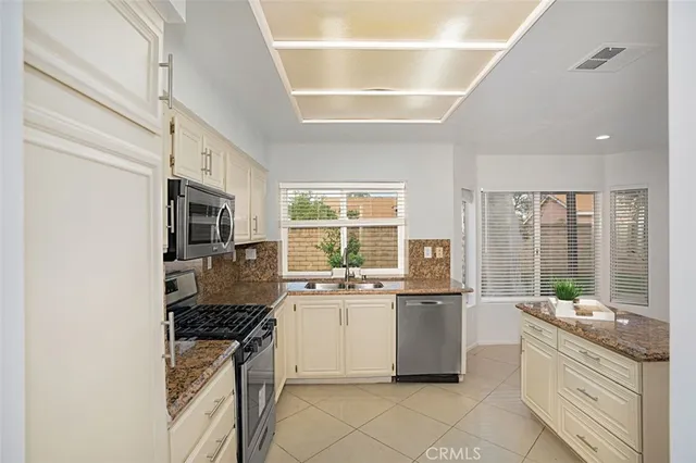 a kitchen with stainless steel appliances granite countertop a stove and a refrigerator
