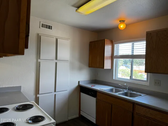 a kitchen with a sink a refrigerator and a window