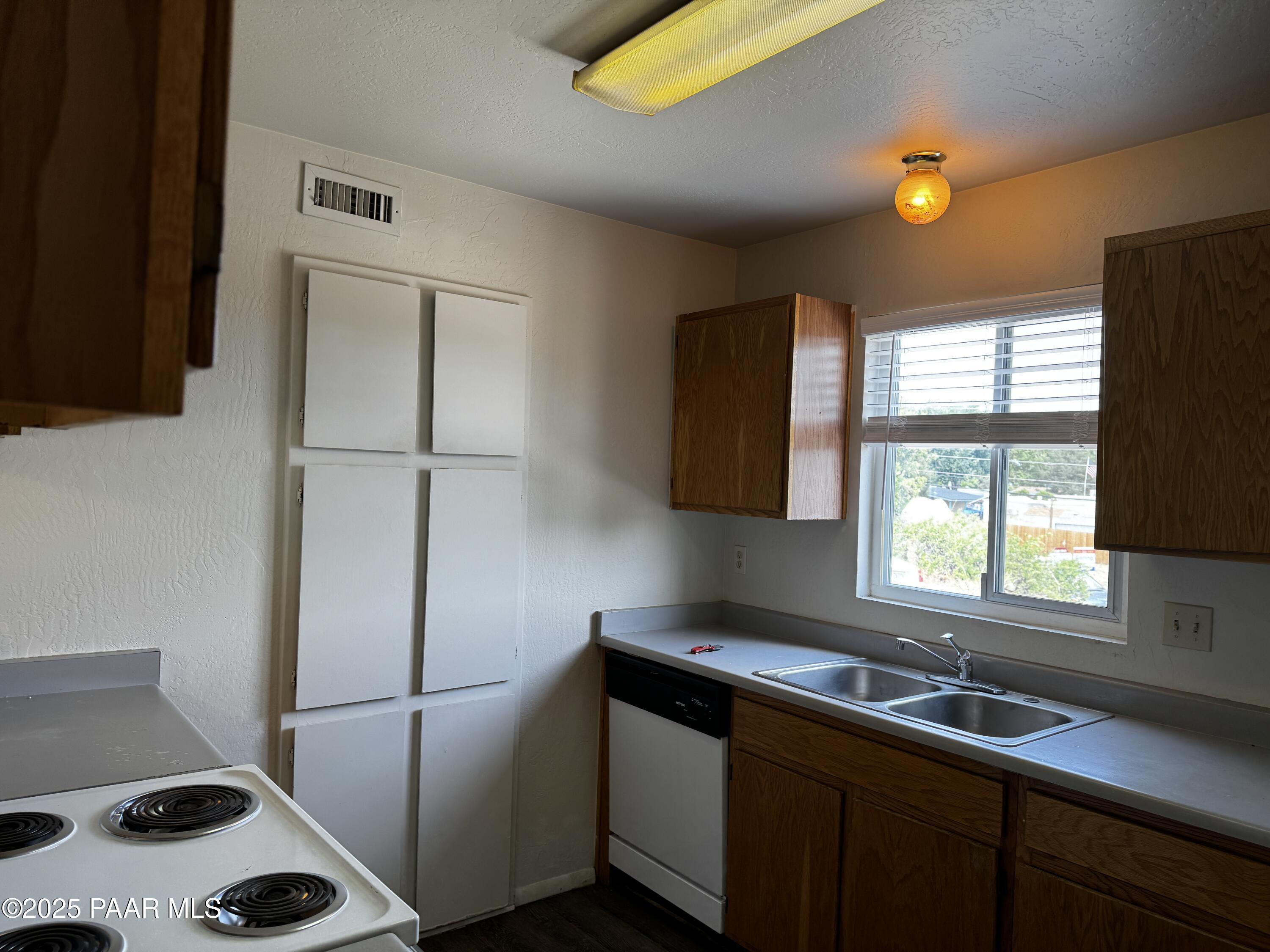 1022 Gail Gardner Way, Unit A Prescott, AZ 86305 - Photo 3 of 6 a kitchen with a sink a refrigerator and a window