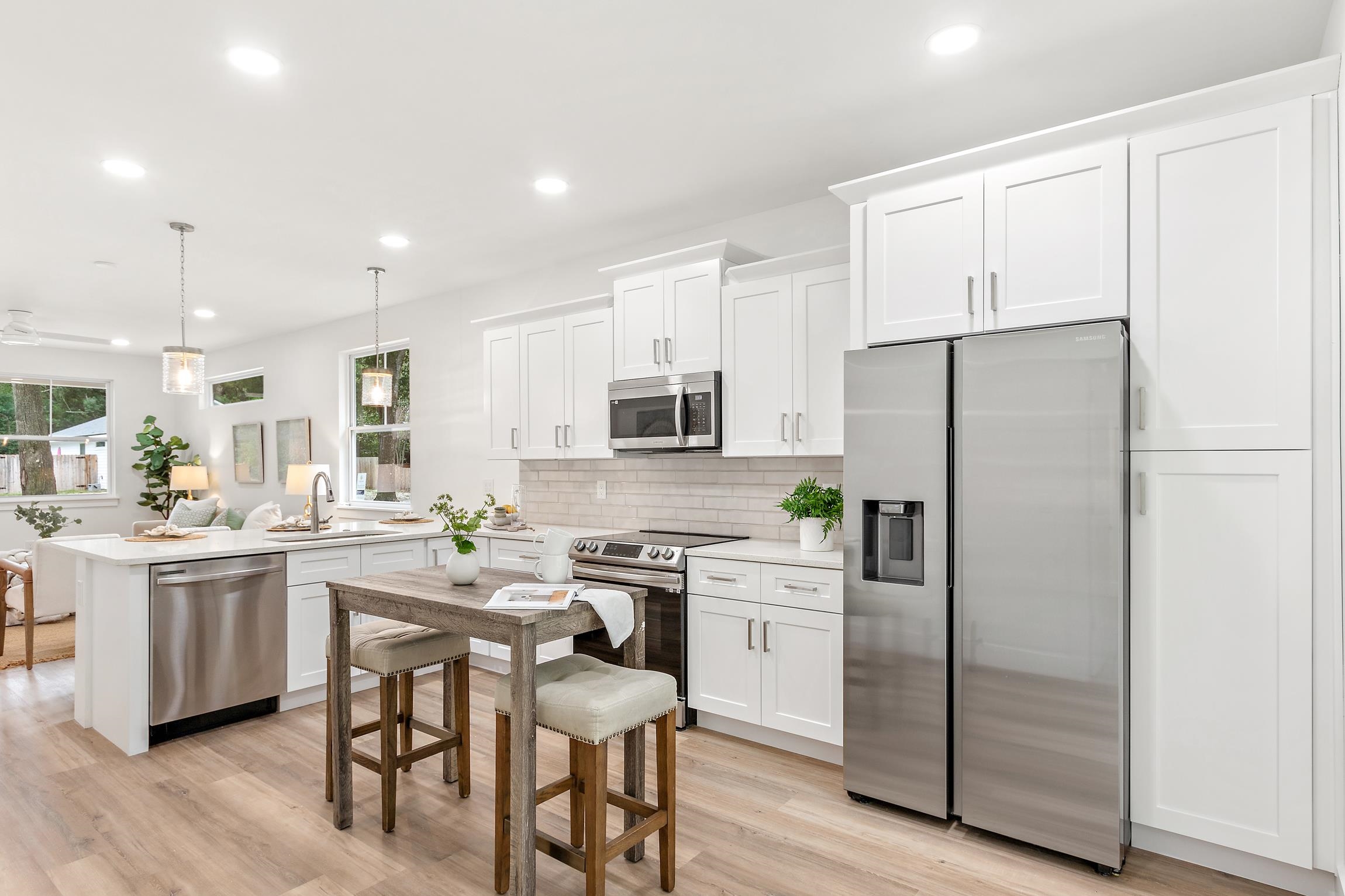 24 River Road St. Augustine, FL 32084 - Photo 11 of 26 a kitchen with stainless steel appliances a refrigerator a stove a sink and white cabinets with wooden floor