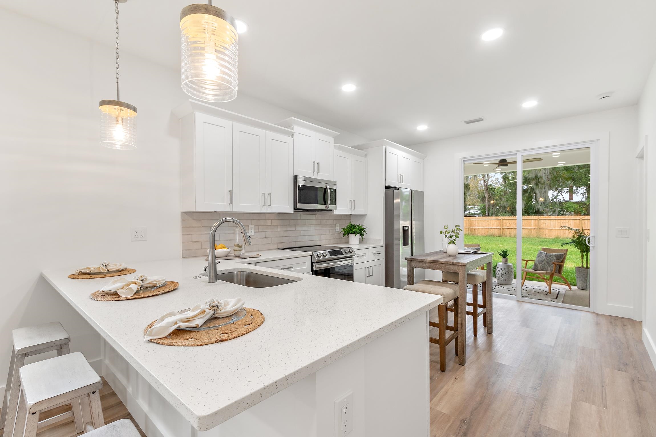 24 River Road St. Augustine, FL 32084 - Photo 9 of 26 a kitchen with a dining table chairs and microwave