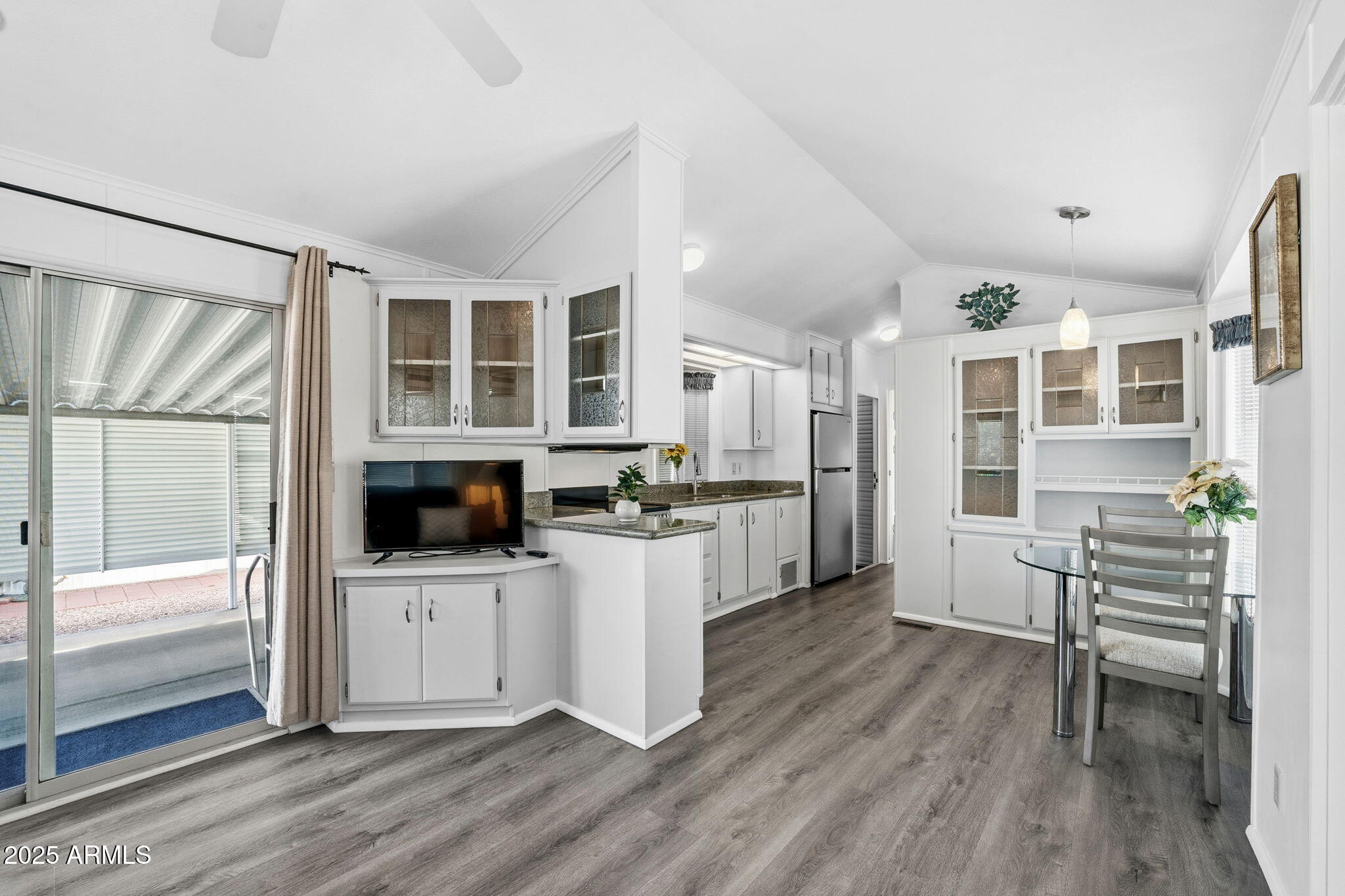 111 South Greenfield Road, Unit 724 Mesa, AZ 85206 - Photo 3 of 23 a kitchen with a wooden floor and white cabinets