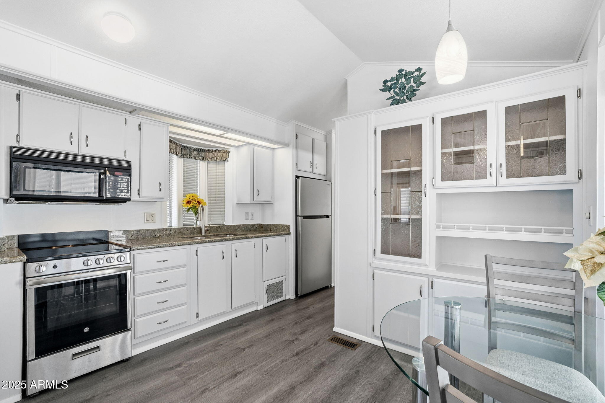 111 South Greenfield Road, Unit 724 Mesa, AZ 85206 - Photo 5 of 23 a kitchen with granite countertop a stove and a wooden floors