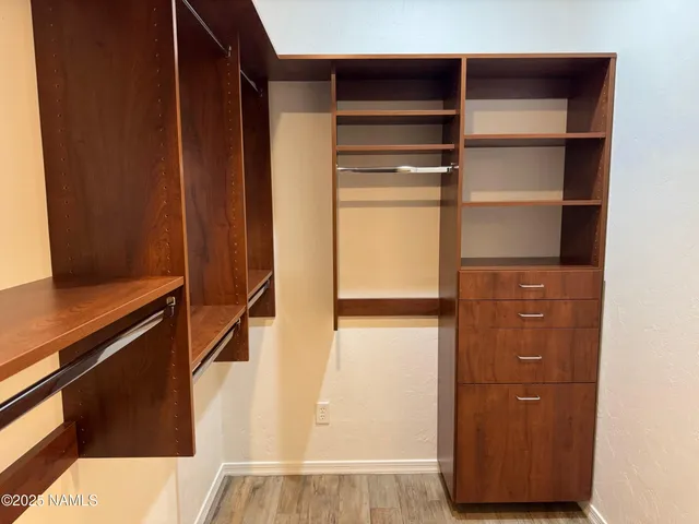 a view of walk in closet with empty racks