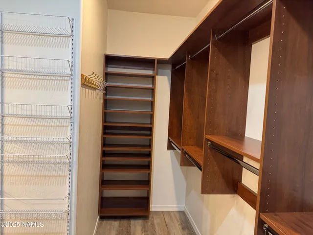 a view of walk in closet with empty racks