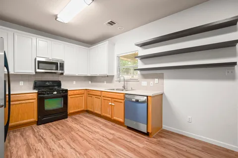 a kitchen with stainless steel appliances granite countertop a stove a sink and a microwave