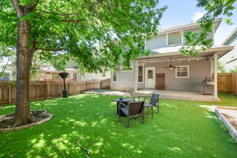 a backyard of a house with table and chairs