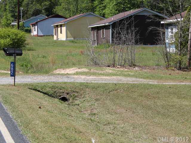 a view of a yard in front of a house with large tree