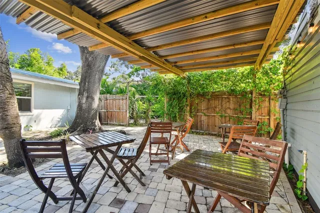a view of a house with a small yard plants and large tree