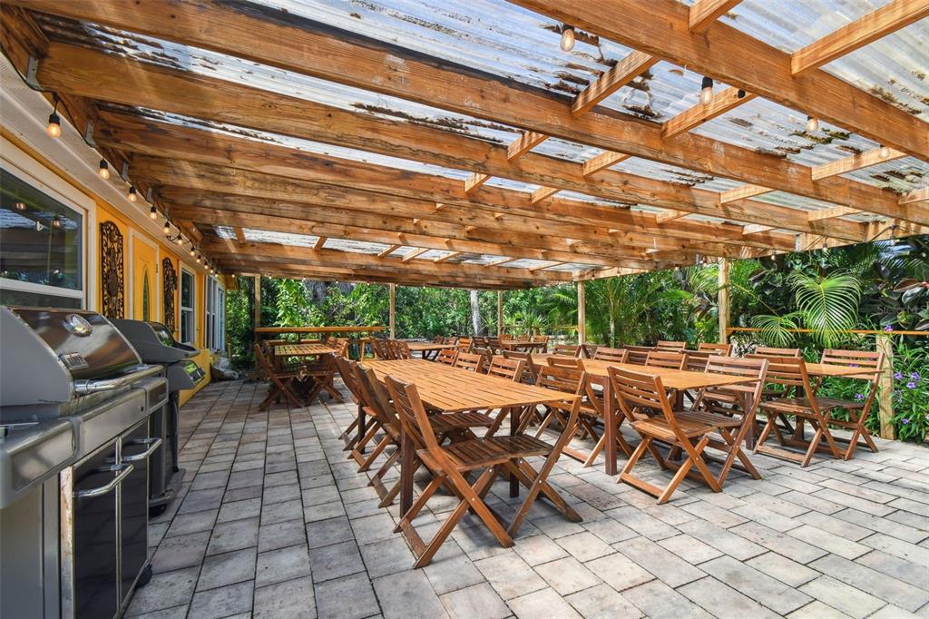 5909 Mohr Road Tampa, FL 33615 - Photo 17 of 48 a view of a patio with table and chairs a barbeque with wooden floor and fence