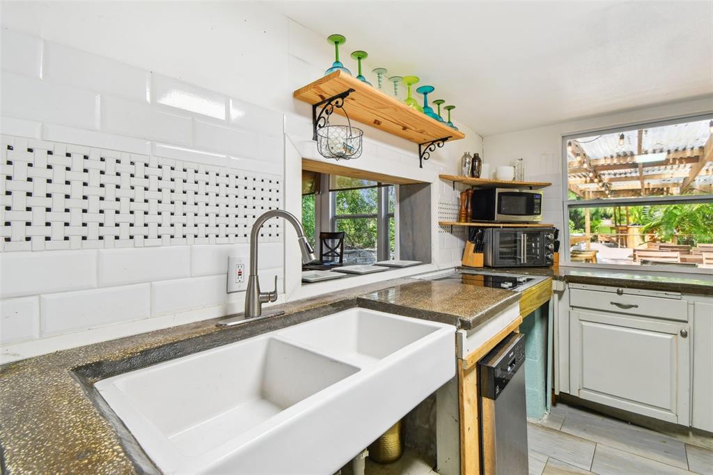 5909 Mohr Road Tampa, FL 33615 - Photo 36 of 48 a kitchen with granite countertop a sink a window and stainless steel appliances