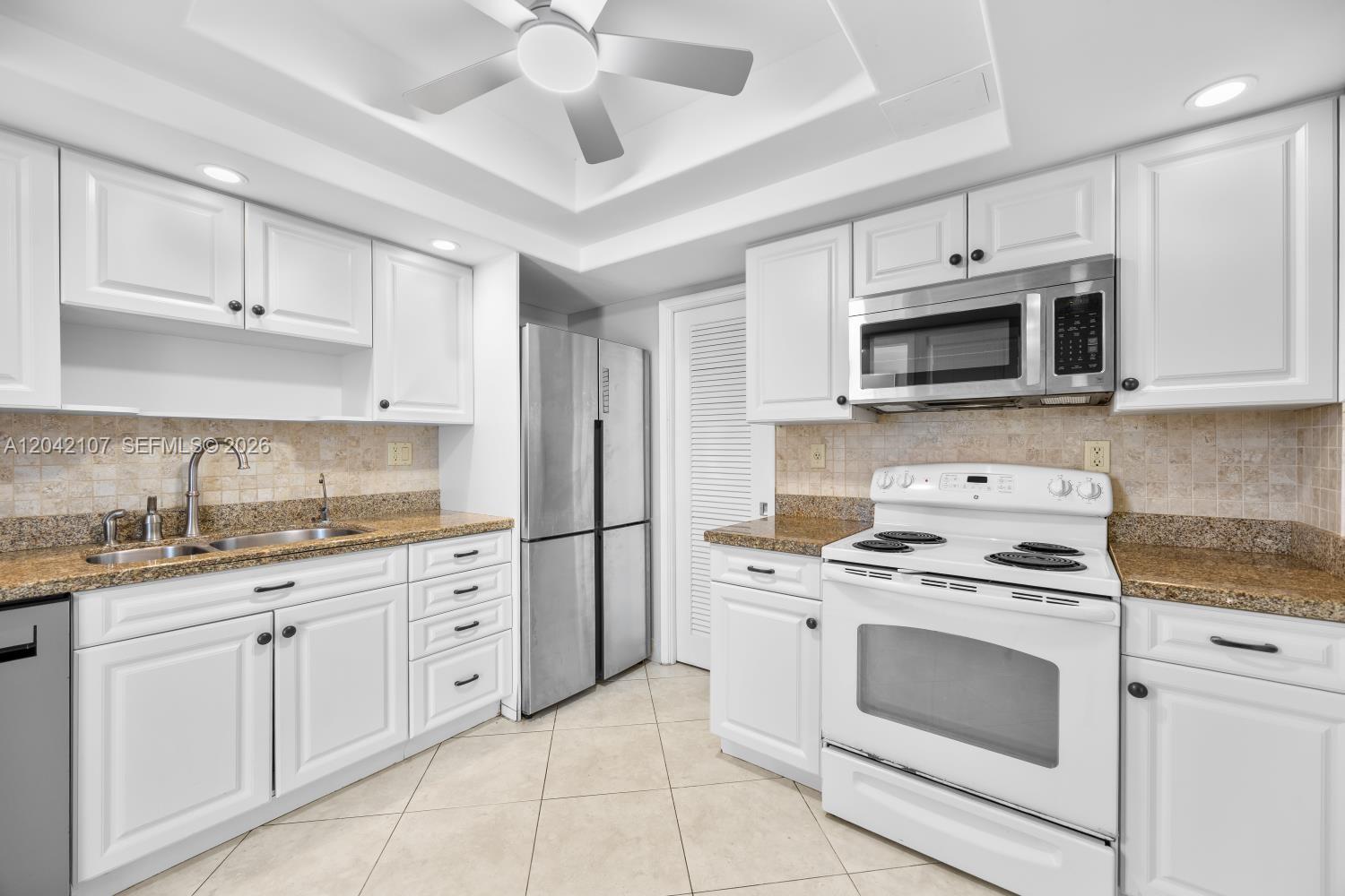 3213 Colony Club Road, Unit 3E Pompano Beach, FL 33062 - Photo 18 of 31 a kitchen with granite countertop cabinets stainless steel appliances and a sink