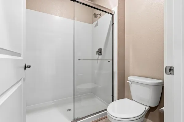 a white toilet next to a bathroom