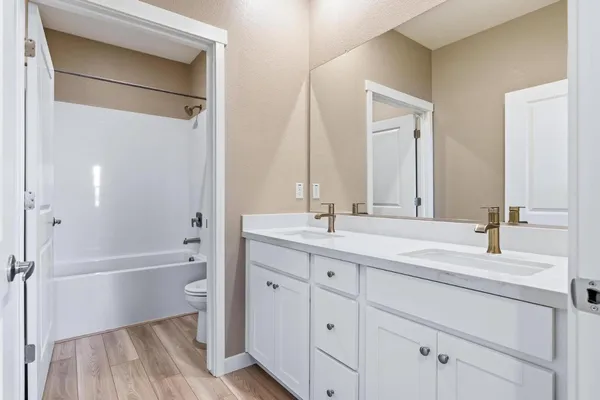 a bathroom with a tub a sink and a large mirror