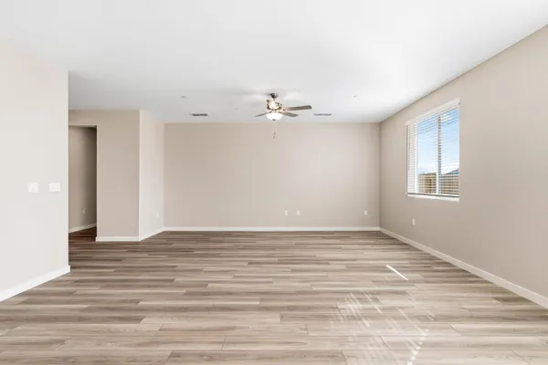a view of an empty room with window and wooden floor