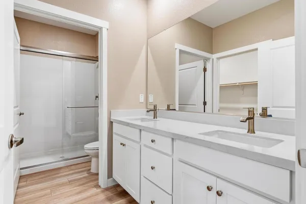 a bathroom with a double vanity sink mirror and shower