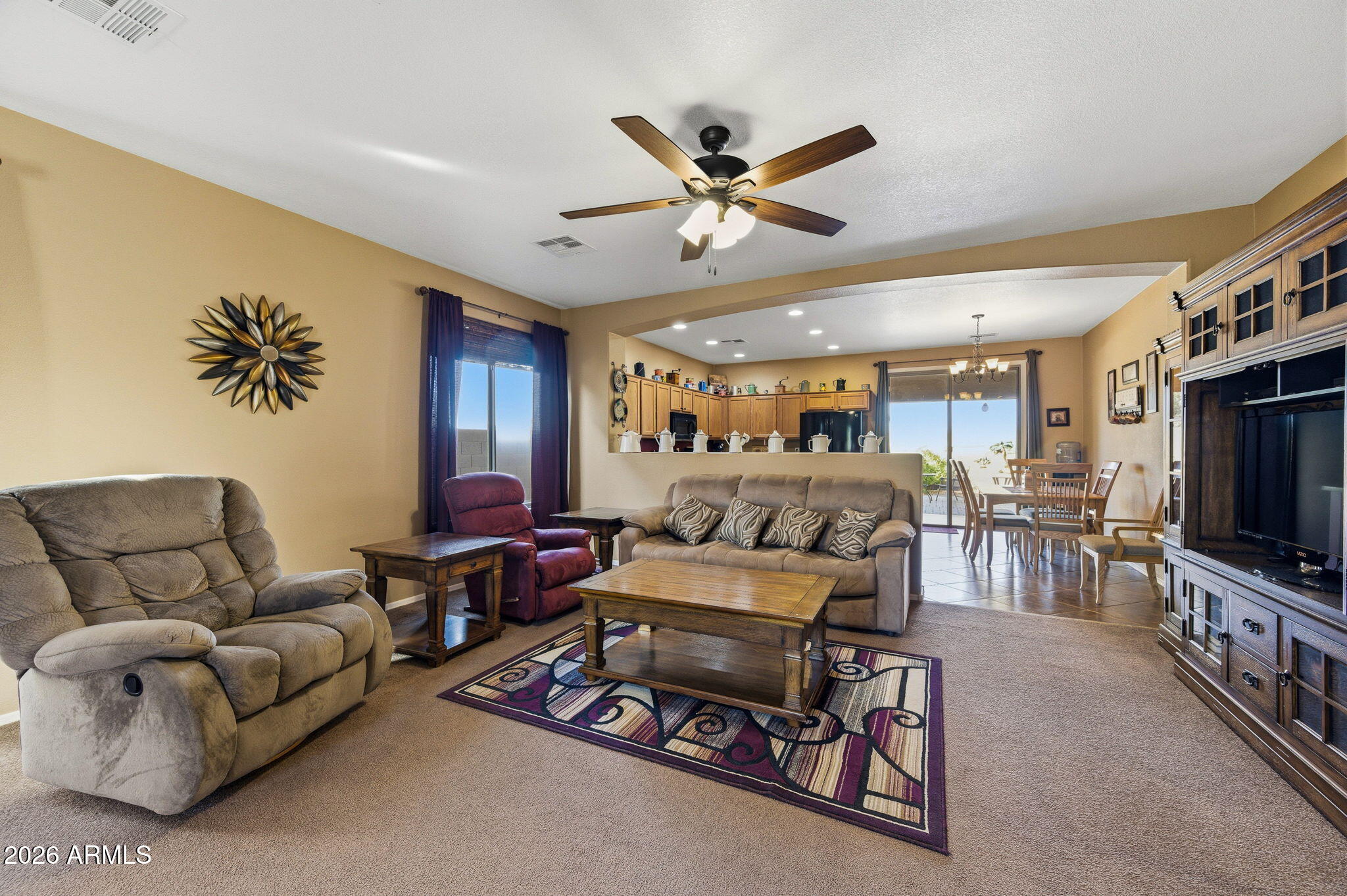 45558 West Mountain View Road Maricopa, AZ 85139 - Photo 3 of 33 a living room with furniture a flat screen tv and a ceiling fan