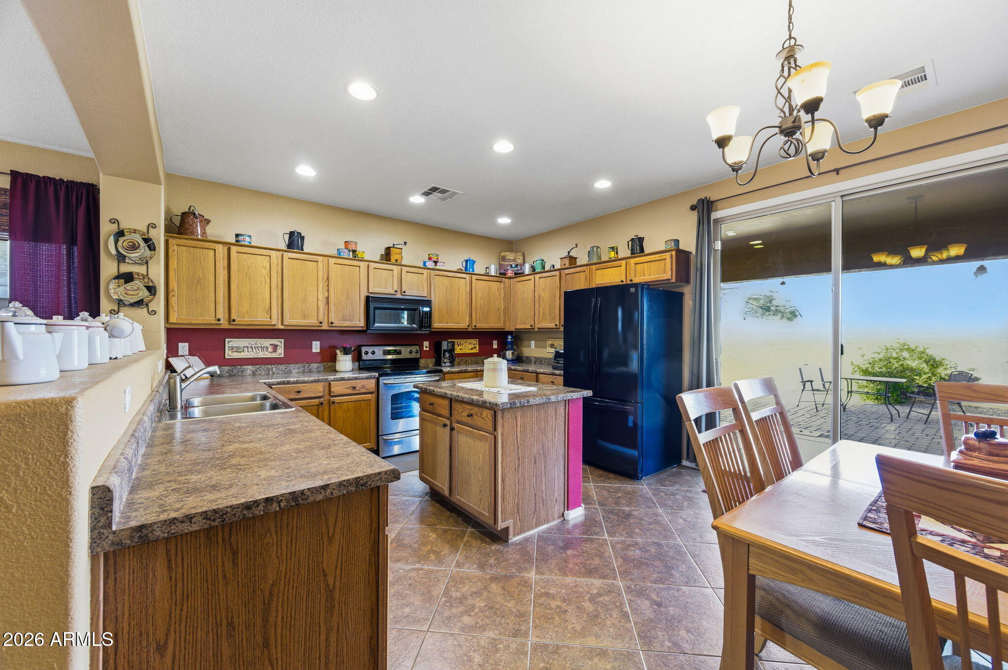 45558 West Mountain View Road Maricopa, AZ 85139 - Photo 5 of 33 a kitchen with refrigerator and chairs