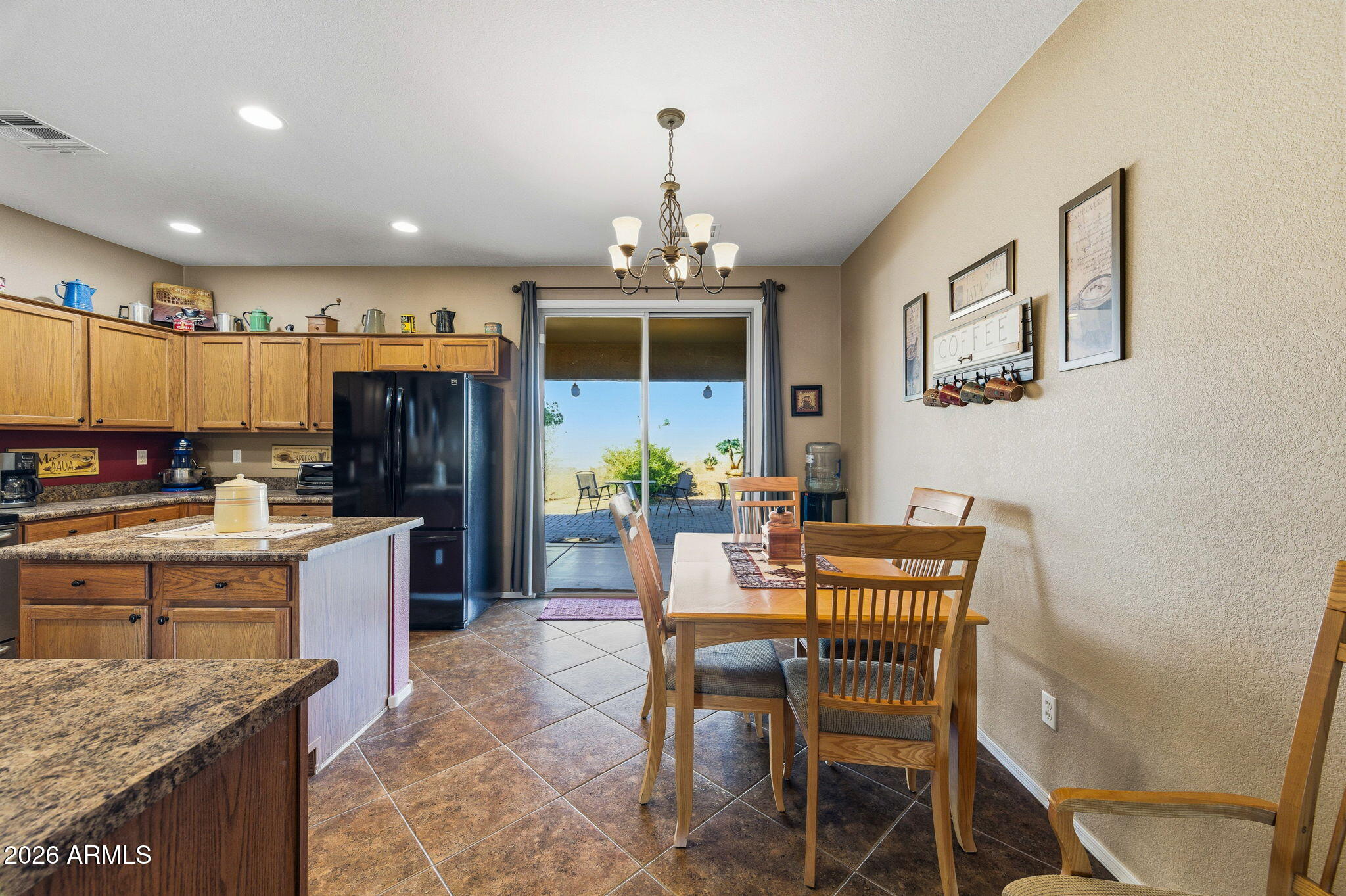 45558 West Mountain View Road Maricopa, AZ 85139 - Photo 6 of 33 a kitchen with stainless steel appliances kitchen island granite countertop a dining table chairs and granite counter tops