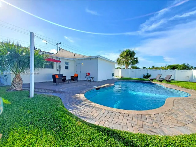 a swimming pool with outdoor seating and yard