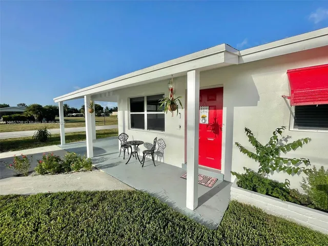 a view of a house with porch and garden