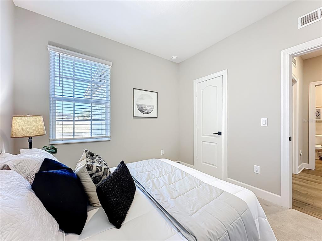 3941 Gareys Ferry Way Middleburg, FL 32068 - Photo 24 of 45 a bedroom with a bed and a lamp