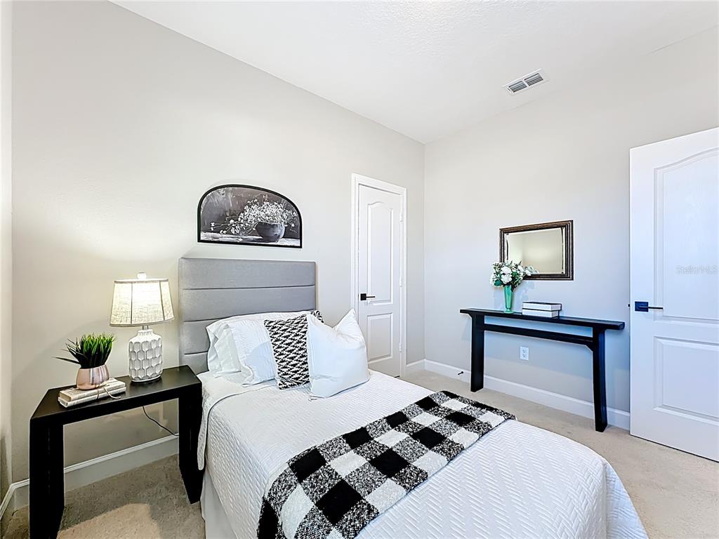 3941 Gareys Ferry Way Middleburg, FL 32068 - Photo 26 of 45 a bedroom with a bed a lamp and a potted plant