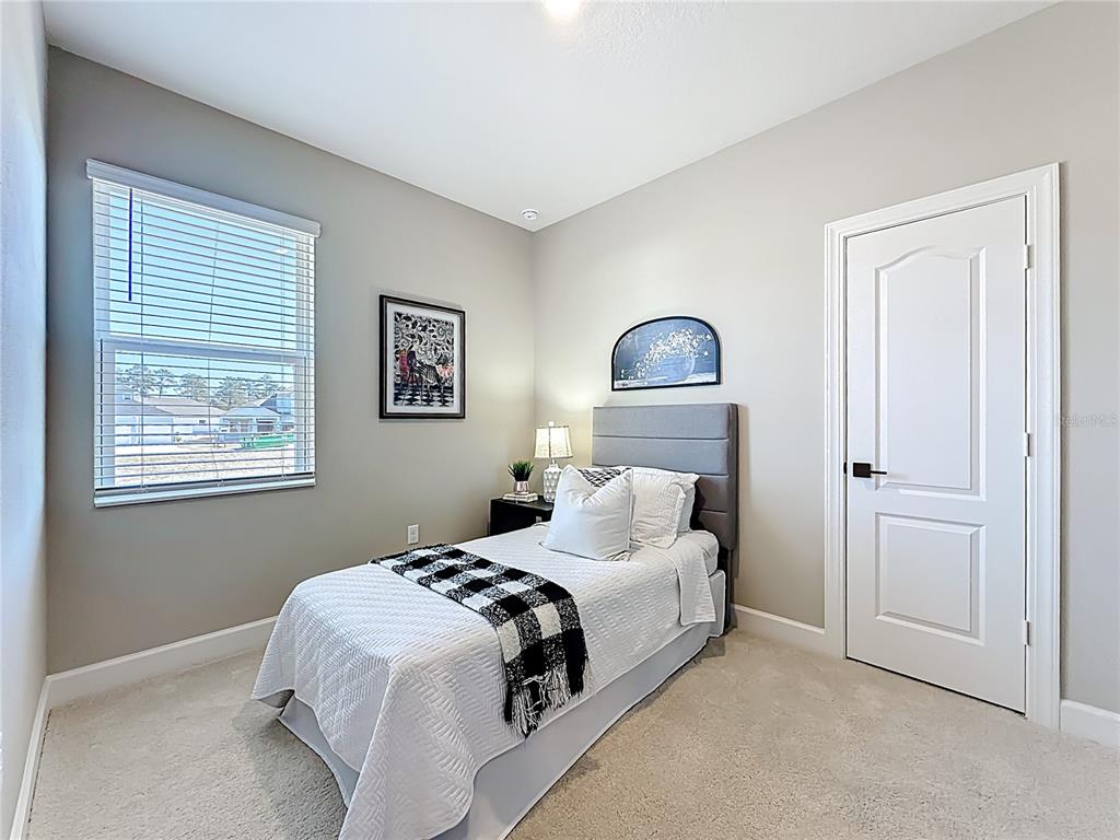 3941 Gareys Ferry Way Middleburg, FL 32068 - Photo 31 of 45 a bedroom with a bed and a lamp