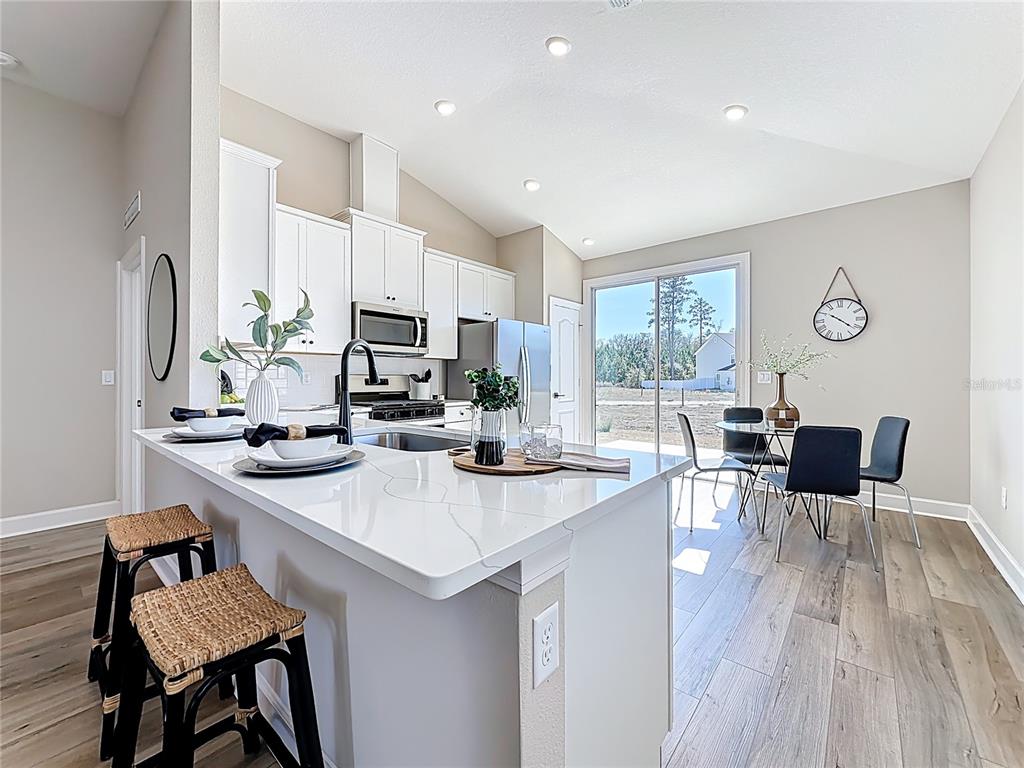 3941 Gareys Ferry Way Middleburg, FL 32068 - Photo 9 of 45 a kitchen with a dining table chairs and refrigerator