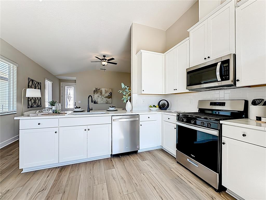 3941 Gareys Ferry Way Middleburg, FL 32068 - Photo 10 of 45 a kitchen with stainless steel appliances granite countertop a stove a sink and white cabinets