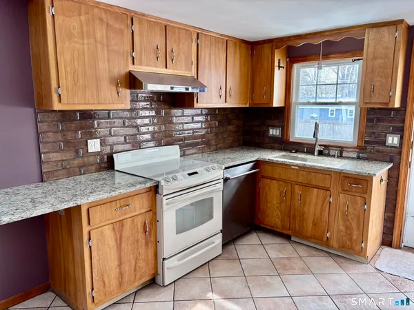 a kitchen with stainless steel appliances granite countertop a sink stove and cabinets