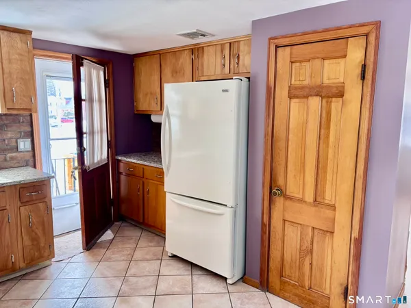 a white refrigerator freezer and a stove sitting inside of a kitchen