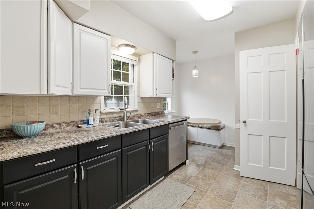 3713 Winchell Road Shaker Heights, OH 44122 - Photo 8 of 38 Kitchen featuring two-tone cabinetry with stainless steel hardware, a dual basin sink, a dishwasher, and a built-in banquette seating area